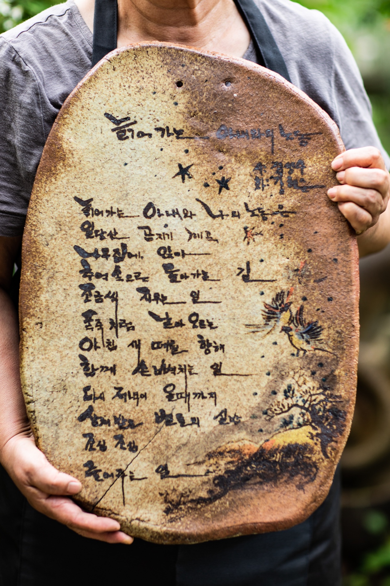 A ceramic plate by the founder's mother, ceramic artist Ucho (Hyunsoon Kang), bearing her painting and a poem by the founder's father, the poet Sungsoo Chung.